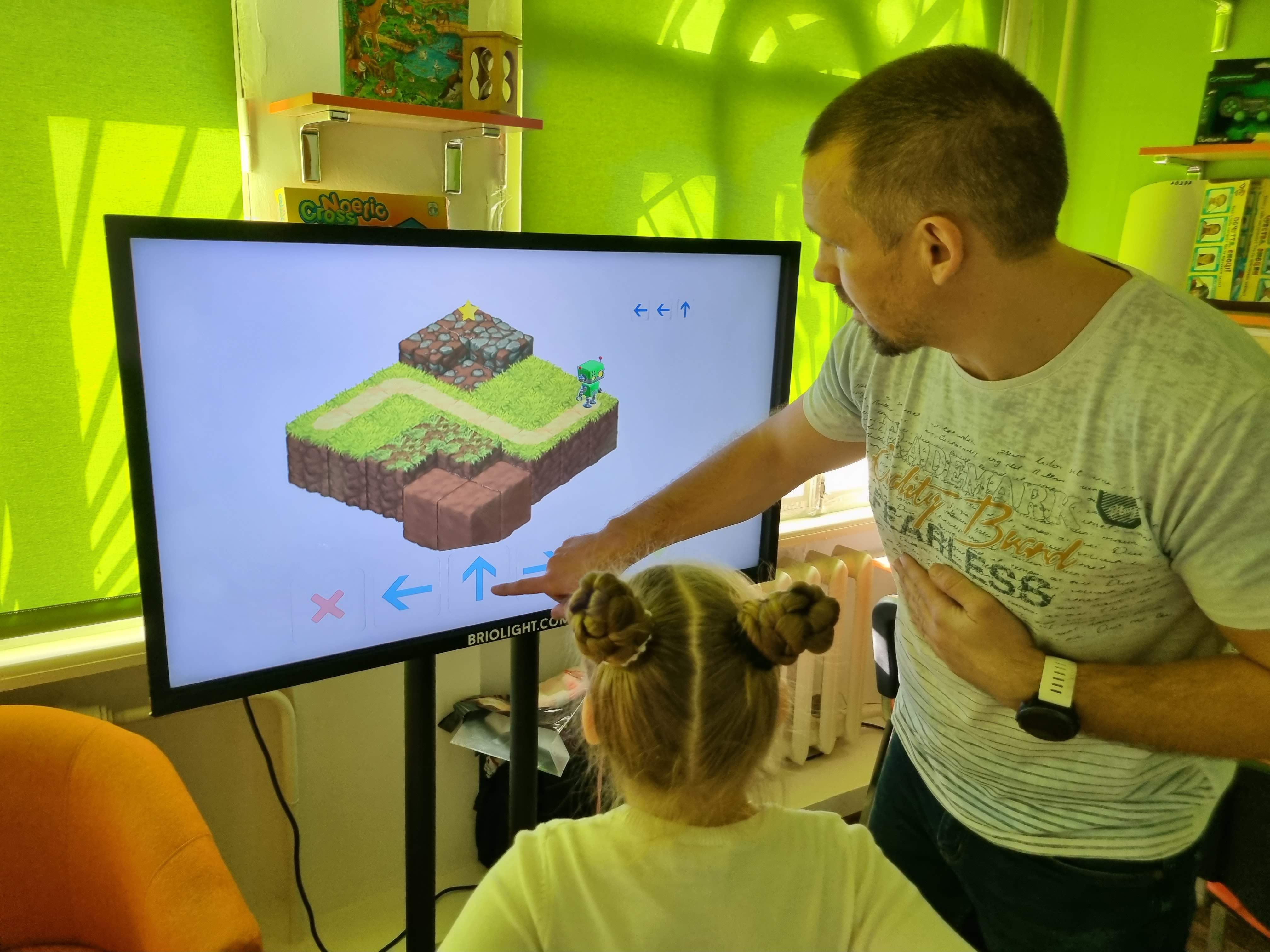 A specialist and child work with a Briolight interactive exercise