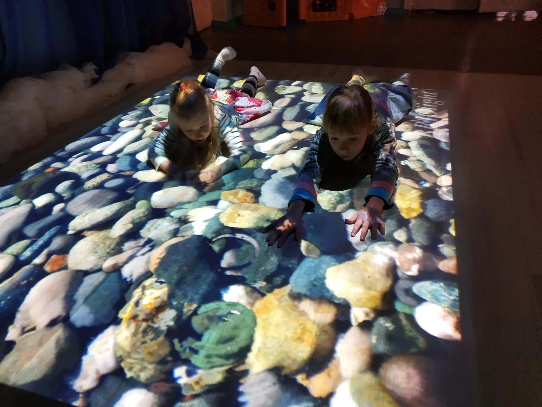 Children interact with a calming Briolight floor projection
